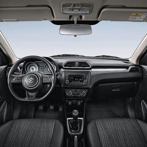 Interior shot of a 2018 Suzuki Dzire showing the dashboard layout with infotainment system and controls.