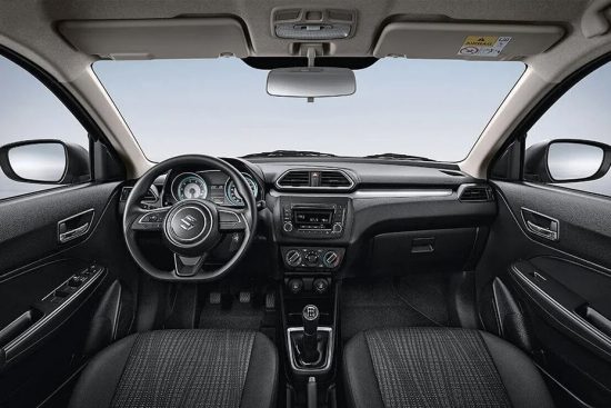 Interior shot of a 2018 Suzuki Dzire showing the dashboard layout with infotainment system and controls.